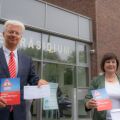  Dr. Joachim Bonn und Dr. Elke Bartels mit der Broschüre "Klüger gegen Betrüger" vor dem Polizeipräsidium Duisburg