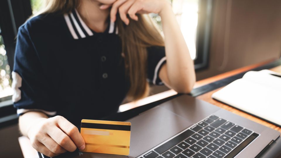 Frau vor PC mit Kreditkarte