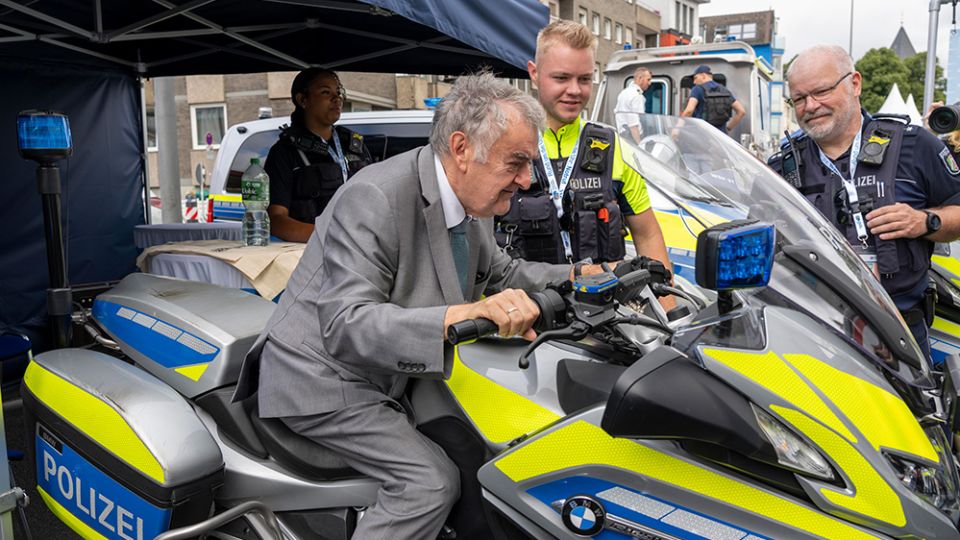 Minister Reul sitzt auf einem Polizeimotorrad