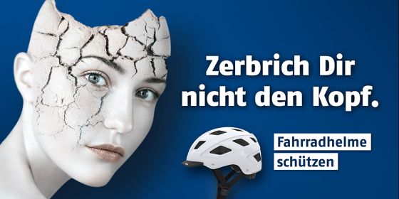Fahrradhelm mit veletztem Kopf und dem Text "Zerbrich Dir nicht den Kopf"